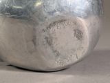 a close up of a silver vase on a table