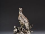 an image of a bronze sculpture of a bird on a rock