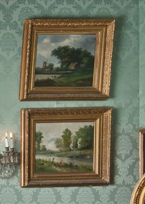 deux tableaux accrochés au mur au-dessus d'un miroir