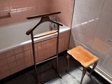 a wooden chair in the bathroom next to a bathtub