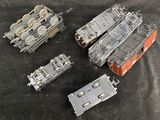 four different models of military vehicles on a black surface