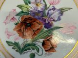 a close up of a plate with flowers painted on it