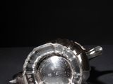 an old silver cup on a black surface with a black background