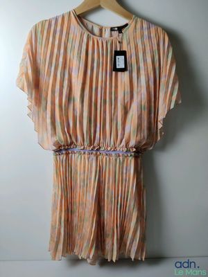 une robe de femme suspendue à un cintre contre un mur
