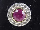 a close up of a ruby and diamond ring on a black velvet surface