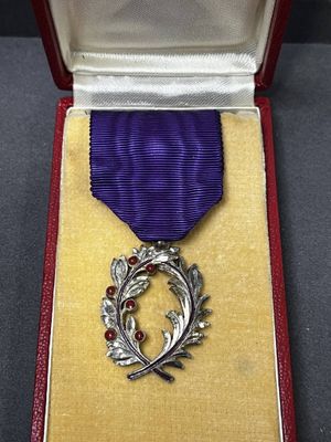 un ruban violet dans un étui rouge, entouré d'un ruban violet