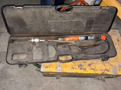 un outil qui se trouve dans la mallette posée par terre