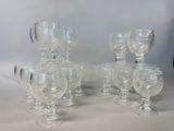 six clear glass goblets are lined up on a table