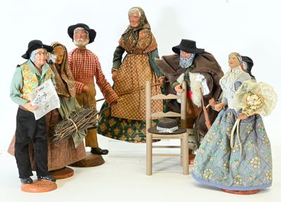 five figurines of people standing next to a chair