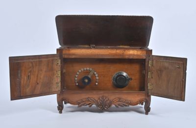 un petit coffre en bois surmonté d'une horloge
