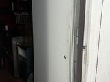 un réfrigérateur blanc dans le coin d'une cuisine