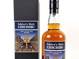 a bottle of whisky sitting next to a box on a white surface