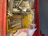 a red box filled with assorted tools in a garage