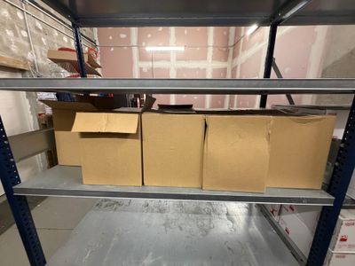 une étagère sur laquelle sont posées des boîtes, au milieu d'une pièce