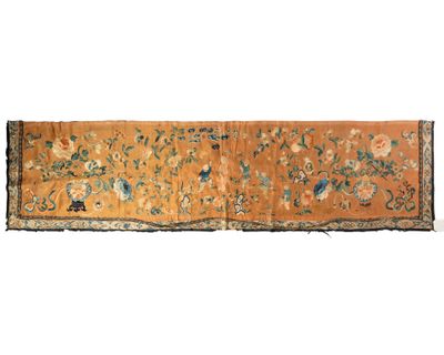 an orange and blue rug with flowers and birds on it