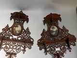 two wooden clocks hanging on the wall next to each other