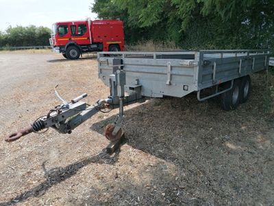 une image représentant une remorque avec un camion de pompiers en arrière-plan