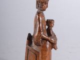 carved wooden statue of a woman holding a baby and a bird