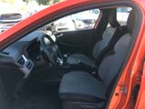 the interior of a red car with black seats and a steering wheel