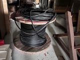 a spool of wires on a wooden stand in a room