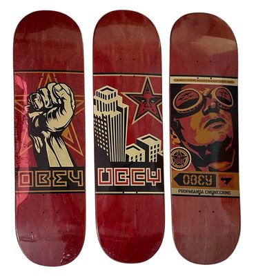 three red skateboards with a picture of a man holding a fist
