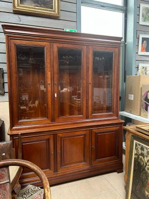 a wooden cabinet with a glass door in a room