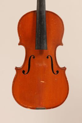 un vieux violon posé sur une table près d'un mur blanc