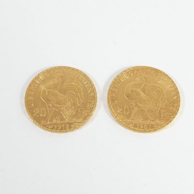 deux pièces d'or posées sur une surface blanche, sur fond blanc