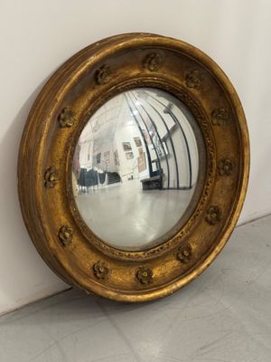 un miroir accroché au mur, à côté d'un mur