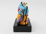brightly colored cat figurine on a black stand with a white background