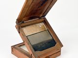 a small wooden box with a mirror inside of it