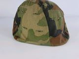 un gros plan d'un casque de camouflage posé sur une surface blanche