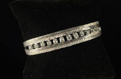 un gros plan d'un bracelet en argent posé sur un anneau en velours noir