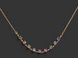 a gold necklace with multi colored stones on a black background