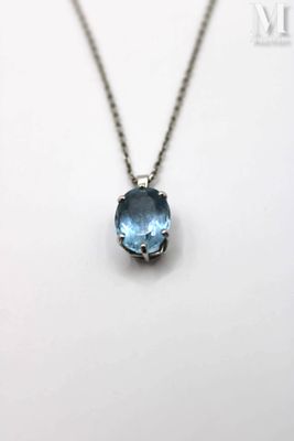 a close up of a necklace with a blue stone on it