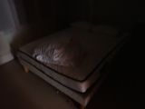 a cat that is laying on a mattress in the dark