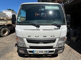 un camion blanc garé sur un parking à côté d'un immeuble