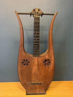 an old wooden instrument sitting on top of a table next to a wall