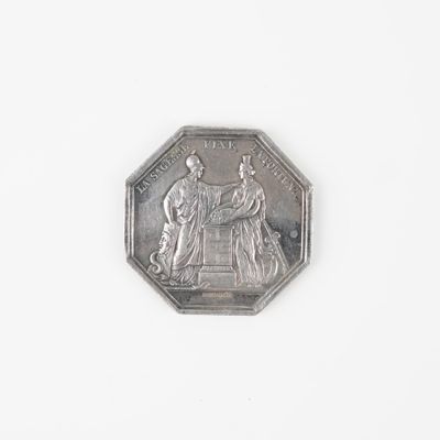une pièce d'argent sur laquelle figurent les portraits d'un homme et d'une femme