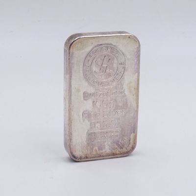 an old silver bar with a small logo on it