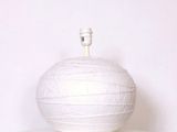 un vase blanc posé sur une étagère blanche