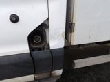 a close up of a white truck with a flat tire