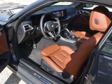 the interior of a car with the door open and the driver ' s seat down