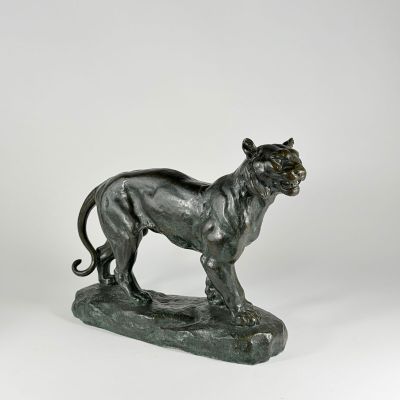 bronze statue of a lion on a rock on a white background