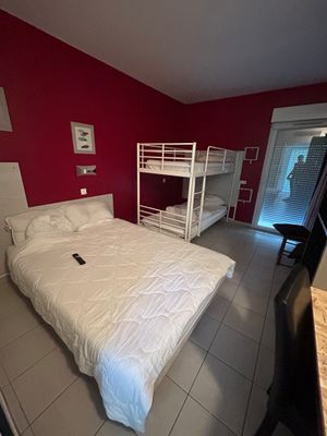une chambre avec un lit et des lits superposés