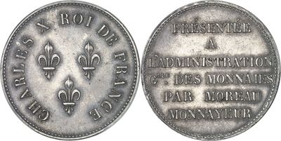 a close up of a silver coin with a fleur on it