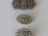 several different types of silver hair clips on a white surface