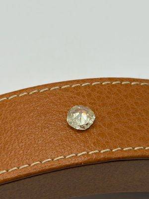 the brown leather belt has a diamond in the center of it