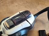 un aspirateur posé par terre à côté d'un aspirateur noir et blanc