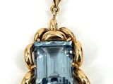un gros plan d'un pendentif en topaze bleue sur fond blanc